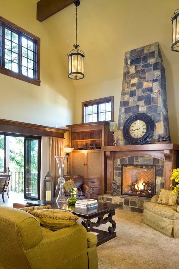 Great room featuring a stone fireplace and skirted chairs.