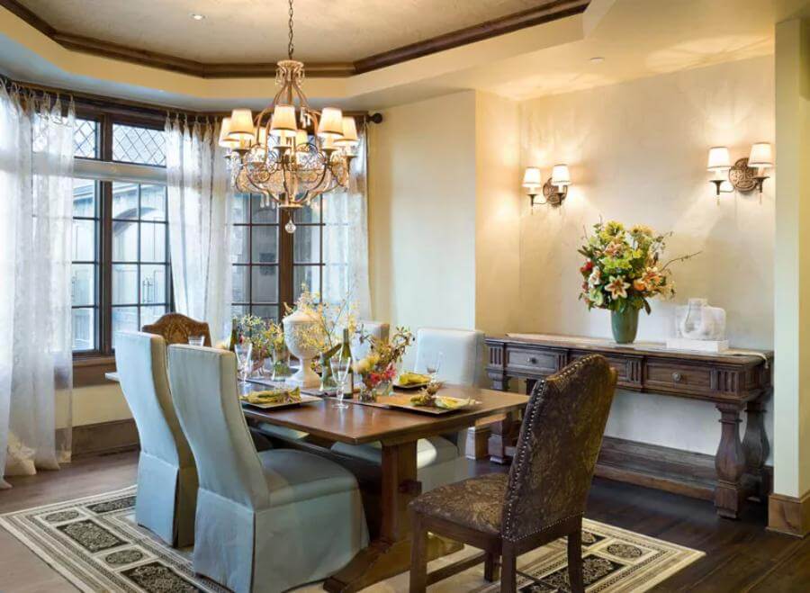 Dining room adorned with a dark wood buffet table and a matching dining set, illuminated by a traditional chandelier.