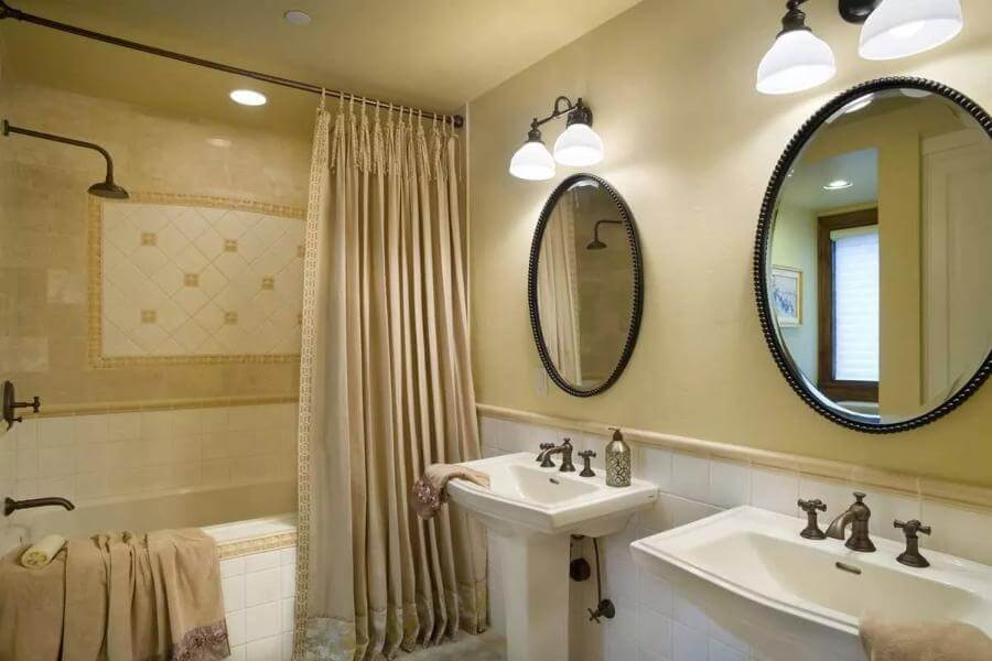 Bathroom displaying two pedestal sinks with a tub and shower combined.