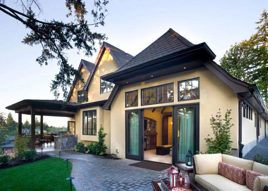 Rear view showcasing sliding glass doors, a covered terrace, and an open patio.