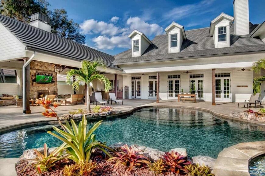 Rear exterior view showcasing the veranda and cabana surrounding the swimming pool.