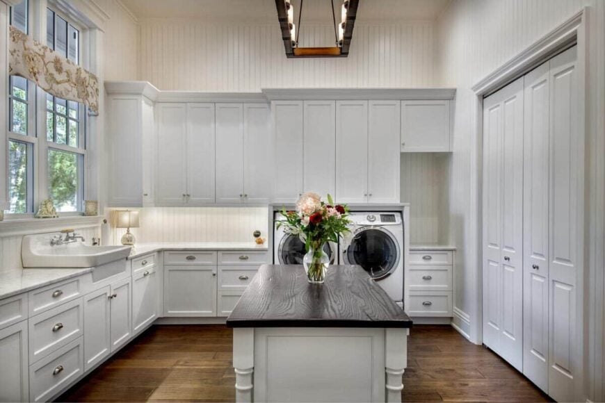 Storage-rich utility room with laundry equipment, utility sink, and a center island.