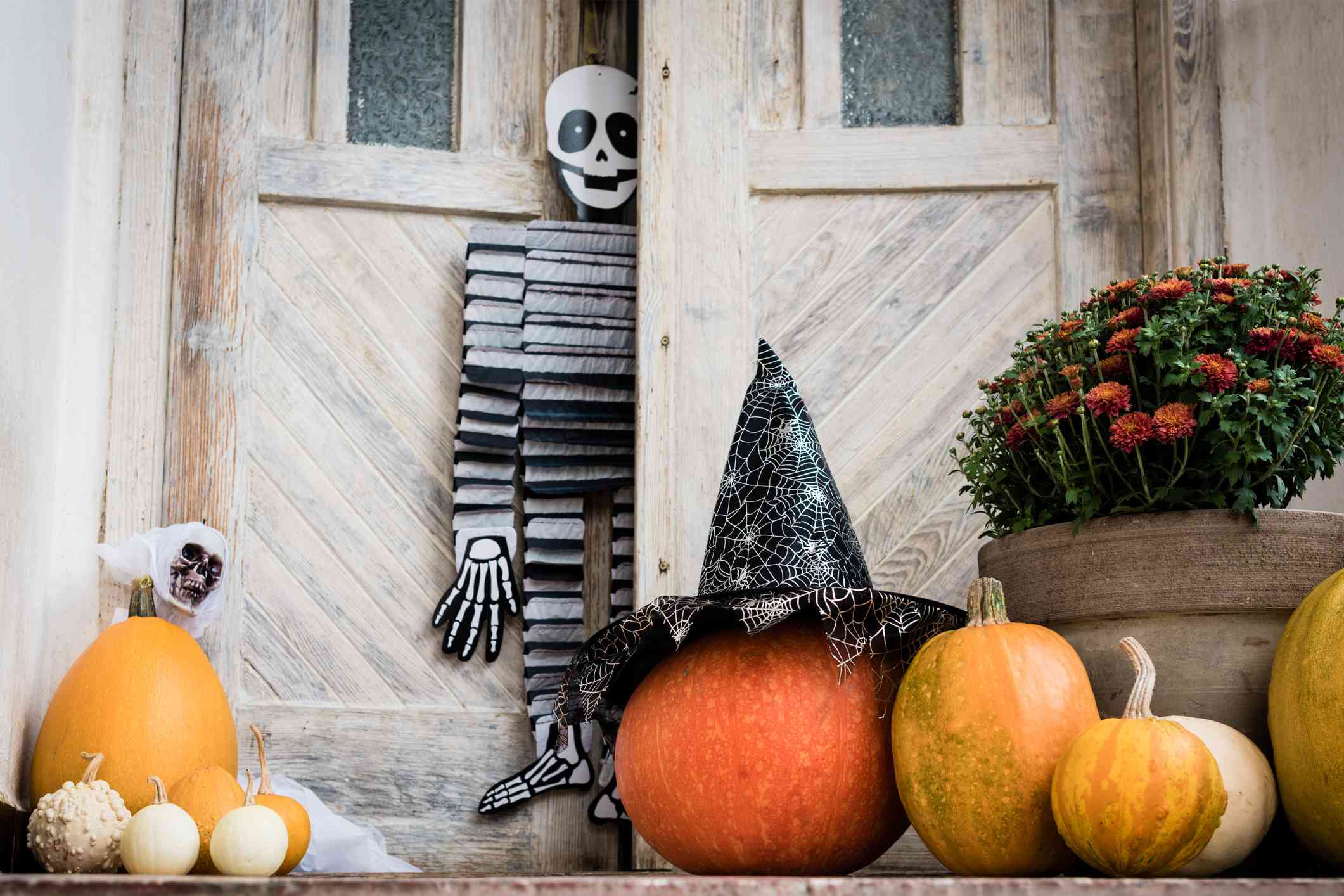 57 Top Outdoor Halloween Decoration Ideas for 2024 5 halloween decorated front door with various size and shape pumpkins and skeletons front porch decorated for the halloween season 1042539328 88cd53b25bd54457afc89f755cdf995f
