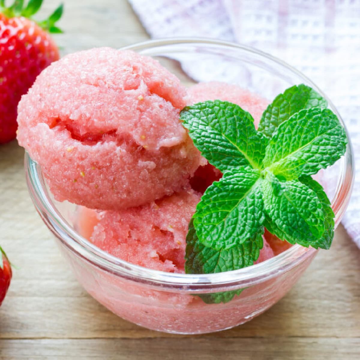 Homemade strawberry sorbet in glass on a wooden table