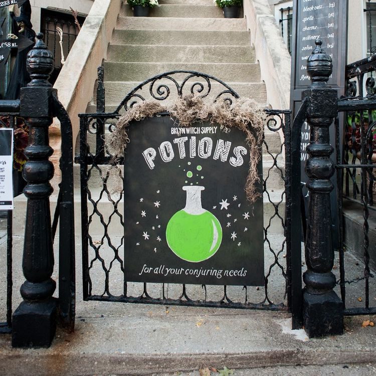 Sign in front of walk-up home with witch potion on it