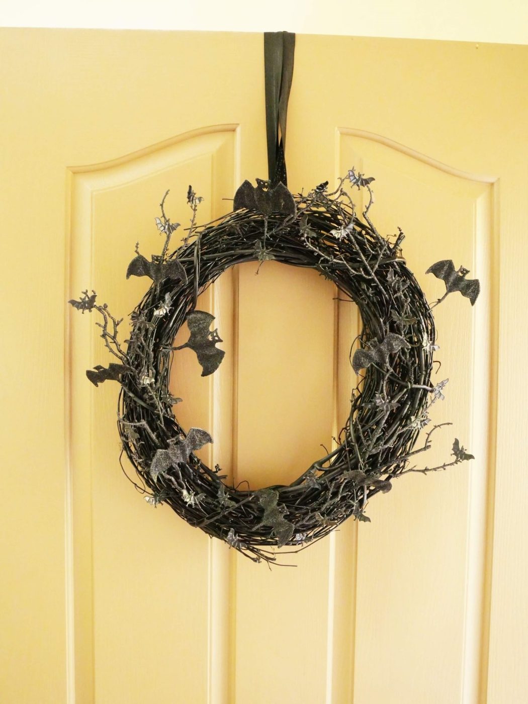 Halloween wreath hanging on white front door