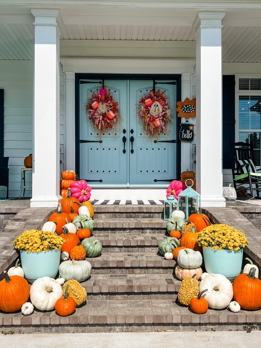 Front porch decorated for fall with various Halloween decorations