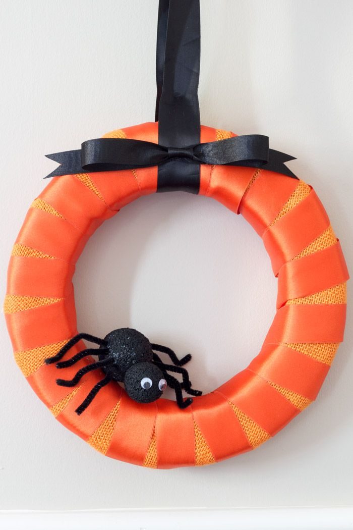 Orange wreath with black bow and spider