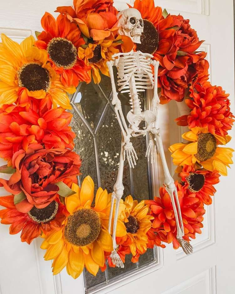 Orange and yellow flower wreath with skeleton in the middle