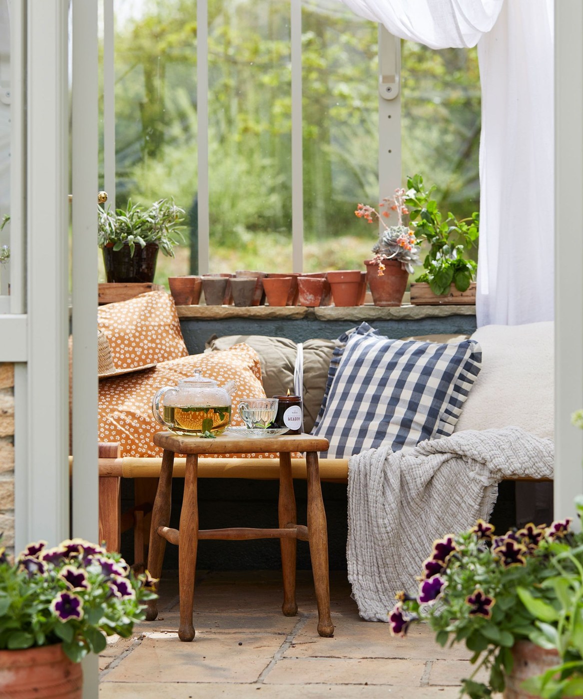 Greenhouse set up as a tranquil tea room with plants
