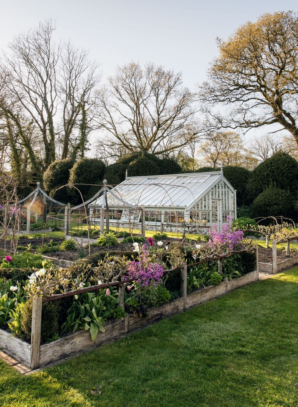 Greenhouse beside a kitchen garden with vegetable beds