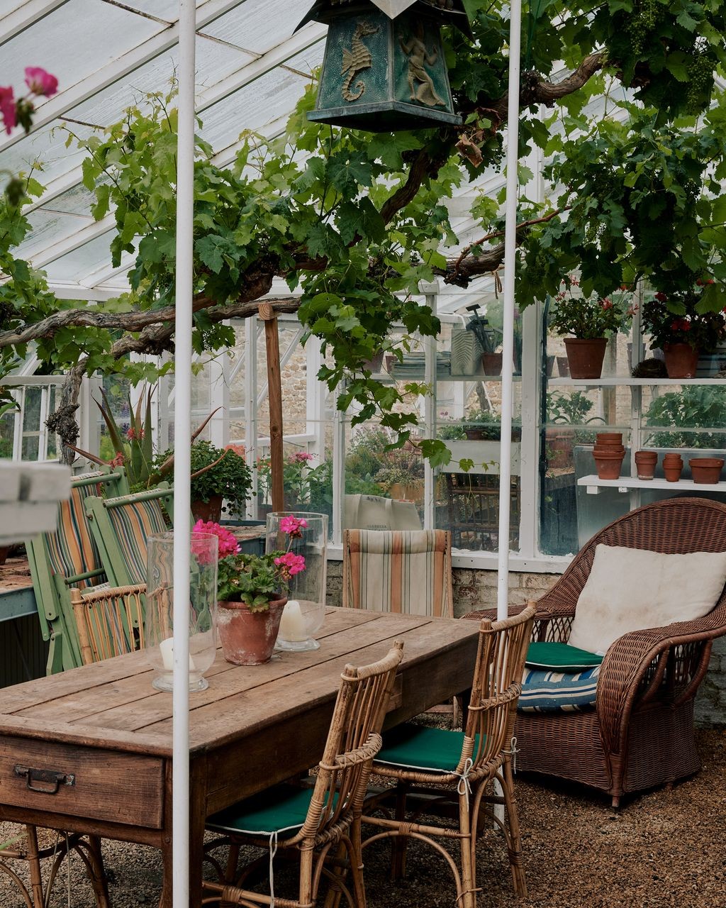 Glasshouse with a wooden dining table and chairs
