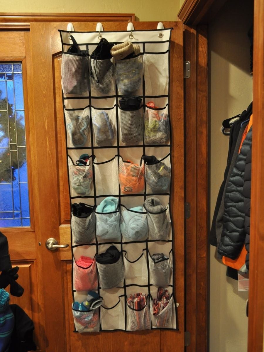 Clear-pocket shoe organizer hanging on the back of a wooden door