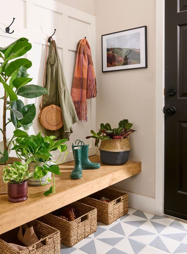 Floating wood bench with woven baskets underneath, coats and hooks above