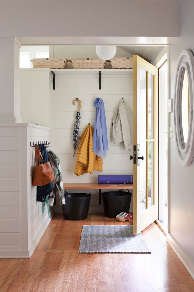 Small mudroom with open wall shelving, hooks and a bench by the back door