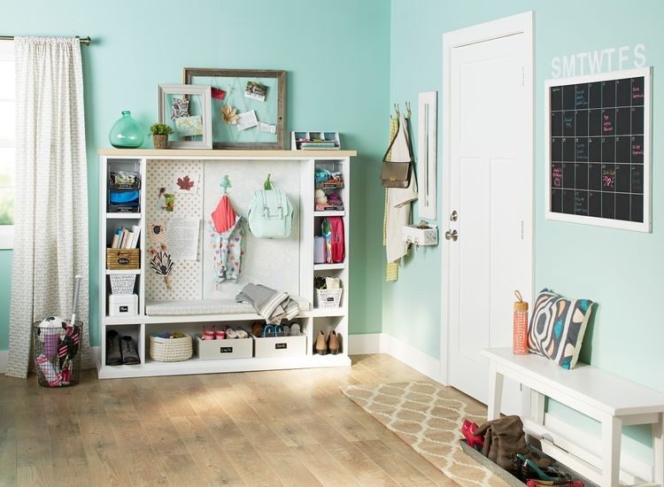 Modular white cube storage unit with bins and hooks in a mudroom corner