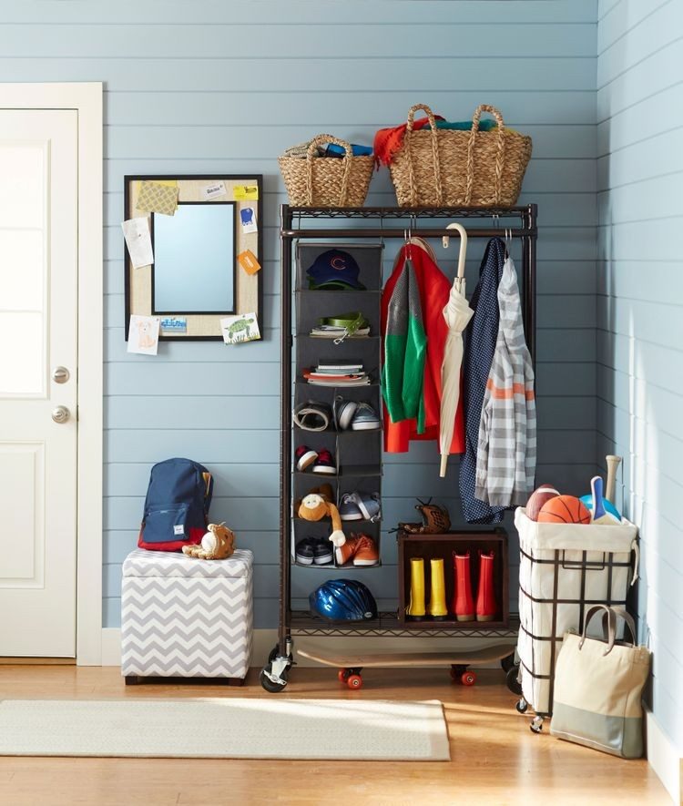 Rolling storage rack with shelves, coats and baskets in a small mudroom