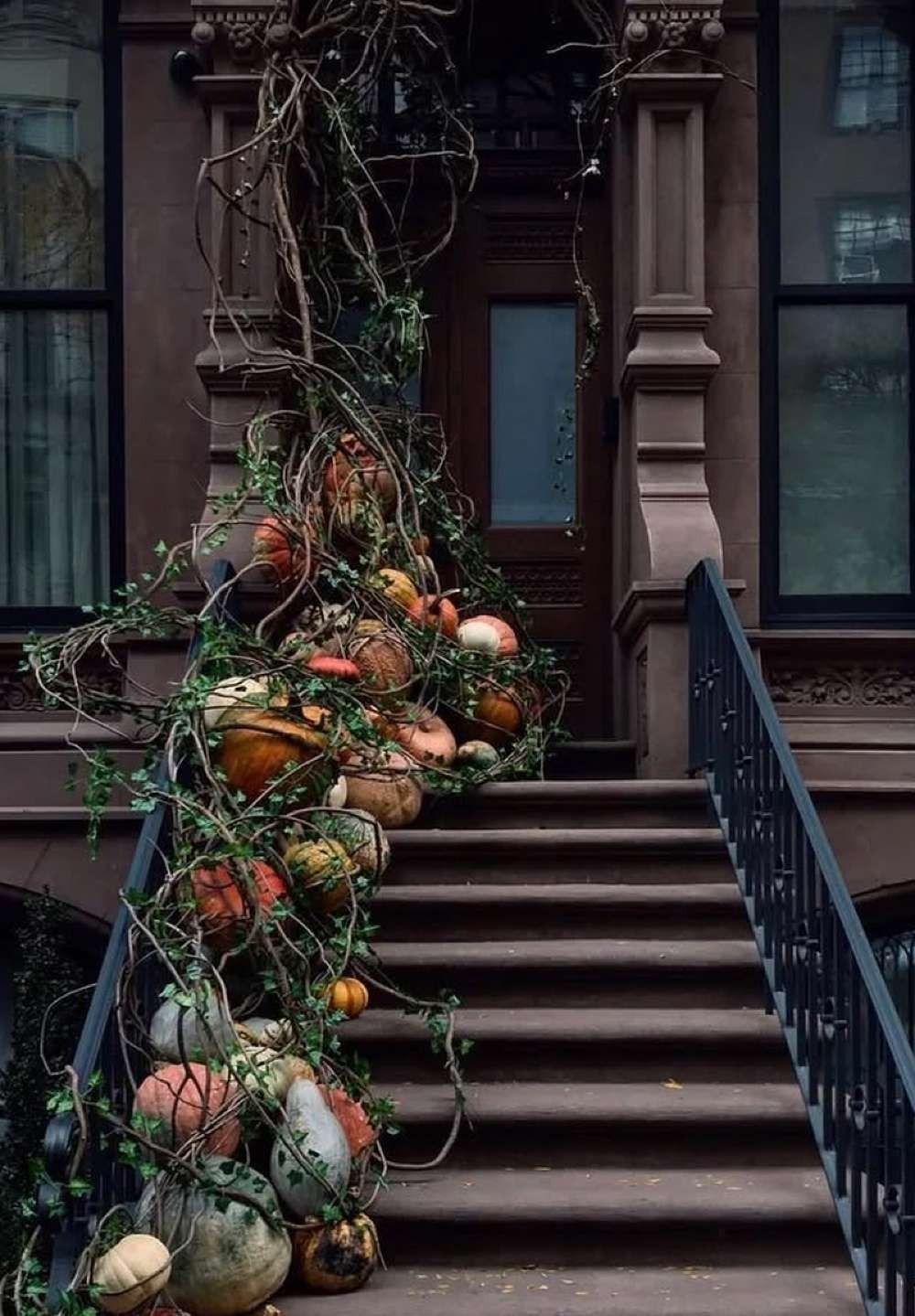 Brownstone stoop with a cascading garland of gourds, pumpkins and autumn foliage down the railing