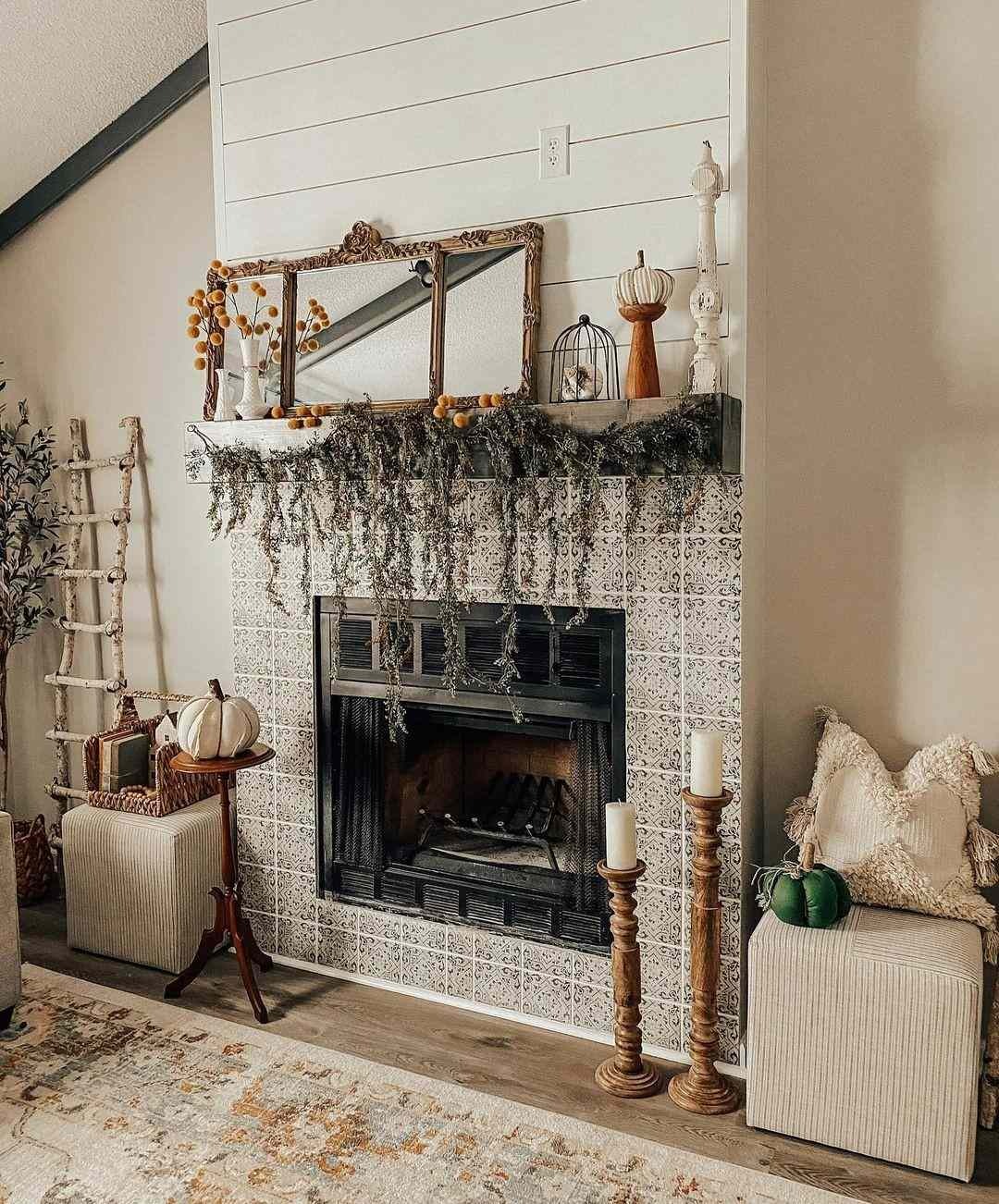 Shiplap fireplace mantel draped with dried greenery and grapevine, with candlesticks and small pumpkins